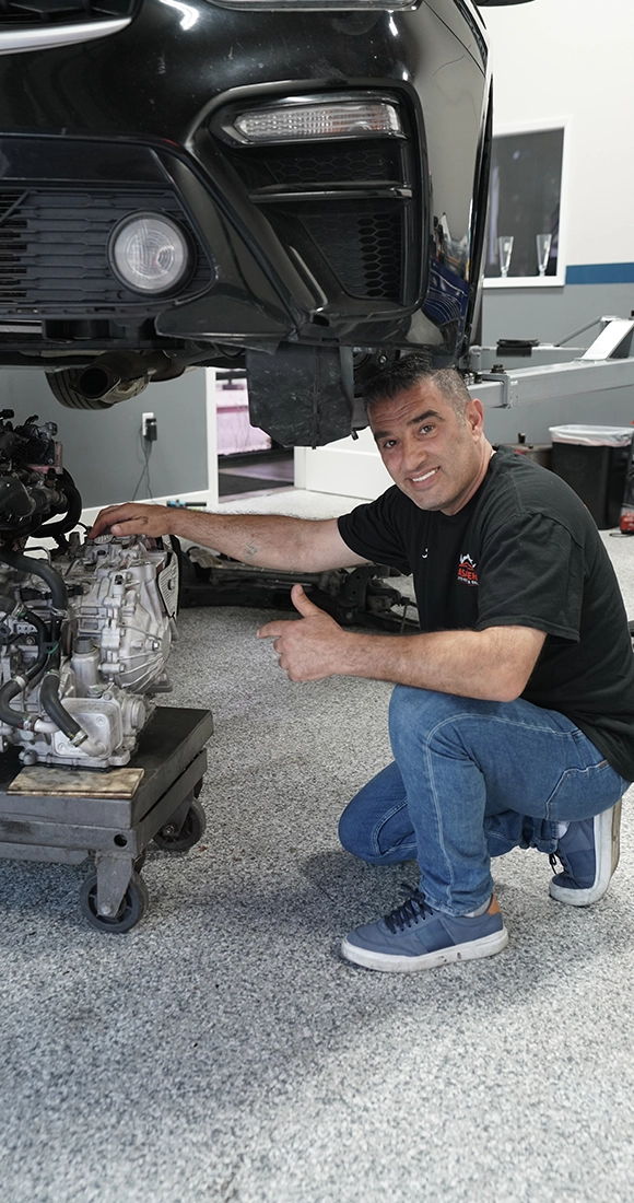 Technician Inspecting Car Transmission at Auto Repair Shop