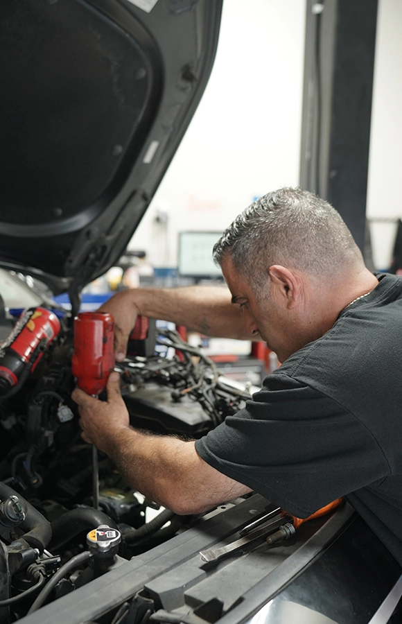 Mechanic Working on Car Engine in Auto Repair Shop